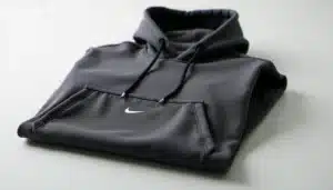 Sweat Nike Tech Fleece gris anthracite avec poche au milieu bien visible, posé à plat sur un fond blanc