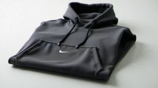 Sweat Nike Tech Fleece gris anthracite avec poche au milieu bien visible, posé à plat sur un fond blanc