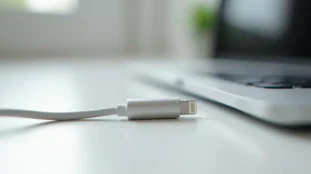 Câble USB Lightning d'apparence ordinaire posé sur un bureau blanc — représentation visuelle d'un omg cable impossible à distinguer à l'œil nu d'un câble standard